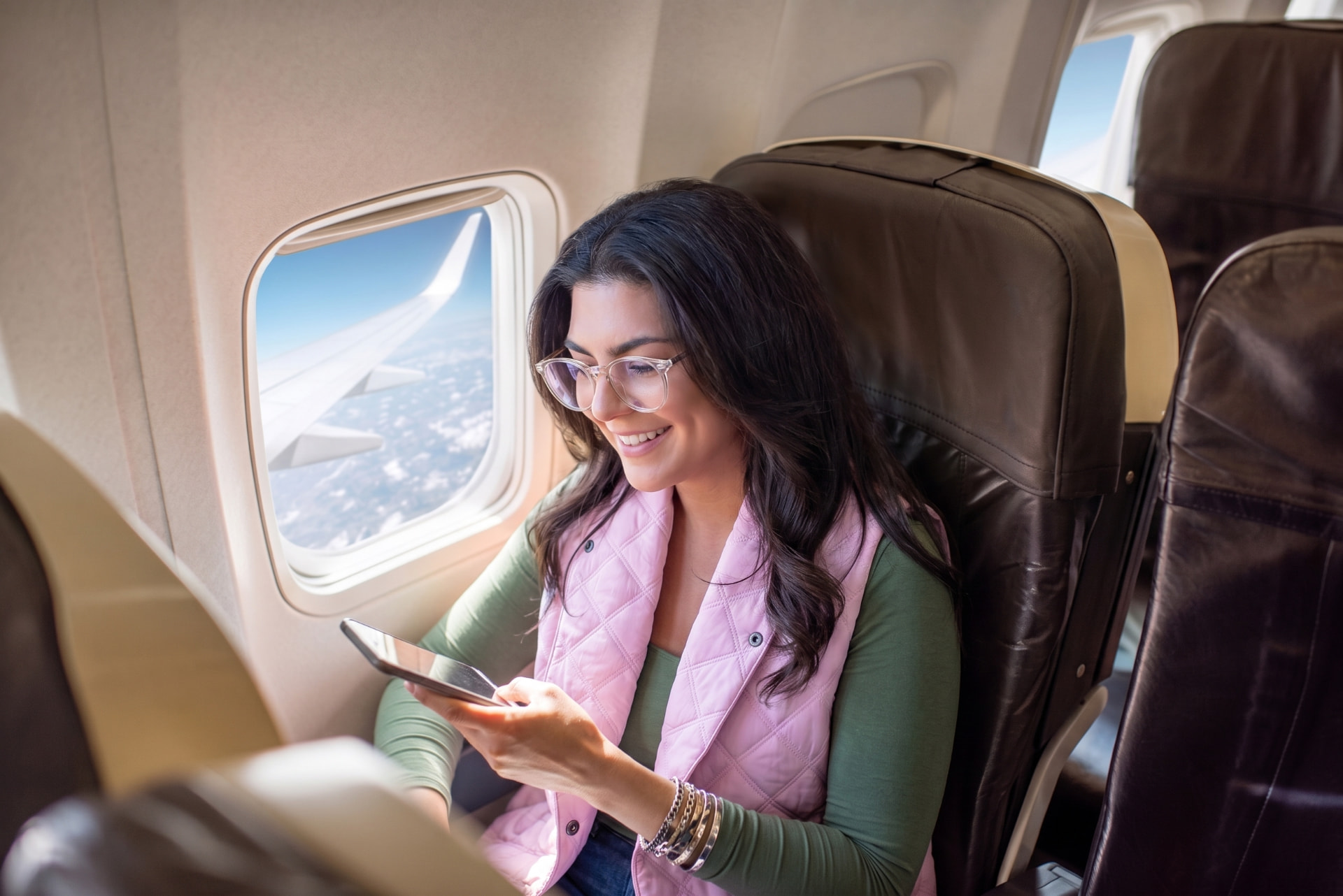 Traveler in an airplane window seat wearing the 418 Scarf as a lavender vest